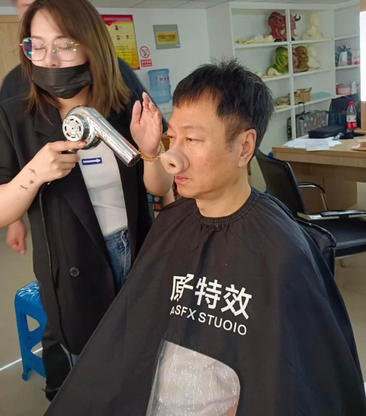 Công đoạn kỳ công nhất là gắn phần tai và mũi giả làm bằng cao su. Tổ hóa trang sử dụng keo cố định vị trí rồi sấy nóng. Ảnh: HK01. Công đoạn kỳ công nhất là gắn phần tai và mũi giả làm bằng cao su. Tổ hóa trang sử dụng keo cố định vị trí rồi sấy nóng. Ảnh: HK01.