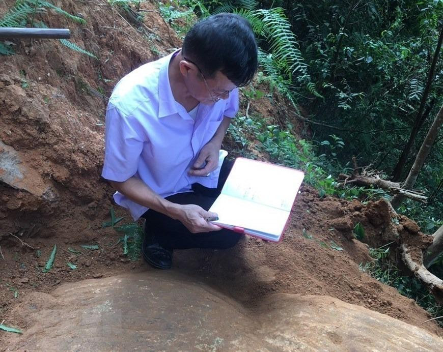 Cán bộ Bảo tàng tỉnh Yên Bái nghiên cứu tổng hợp về những khối đá khắc cổ mới được phát hiện tại thôn Háng Chua Say, xã Chế Cu Nha, huyện Mù Cang Chải. (Ảnh: TTXVN phát)