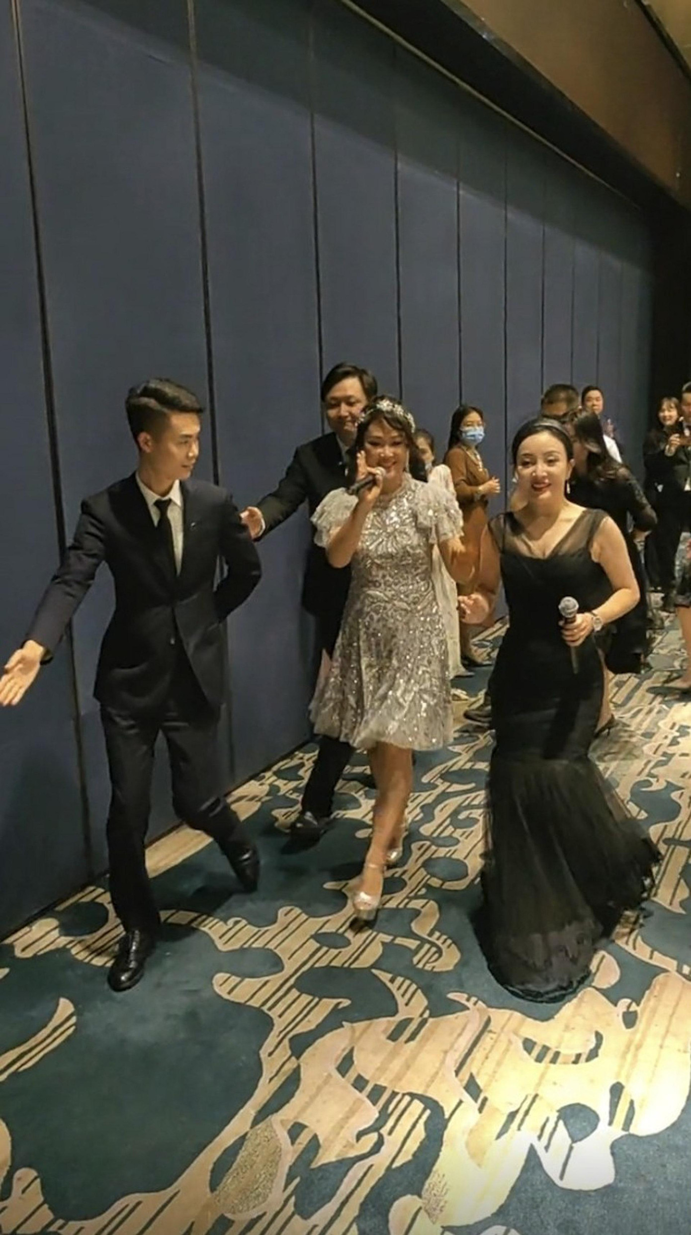 Lương Tiểu Băng mặc đầm lấp lánh và được vệ sĩ hộ tống. Ảnh: HK01. Lương Tiểu Băng mặc đầm lấp lánh và được vệ sĩ hộ tống. Ảnh: HK01.