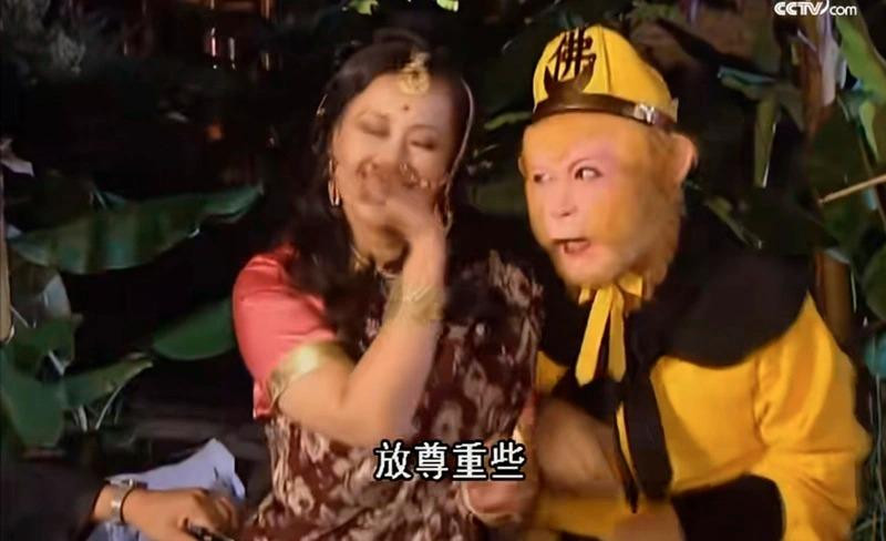 Cánh tay của nhân viên hậu trường ẩn hiện phía sau diễn viên nữ.