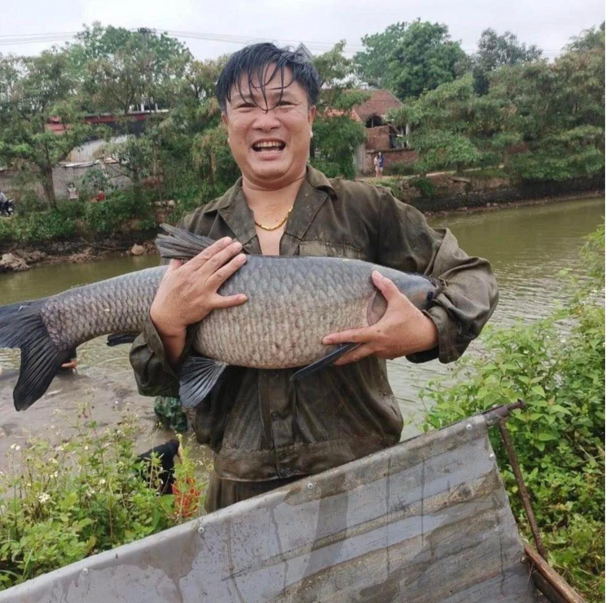 Một người dân hào hứng, vẻ mặt rạng rỡ sau khi thu hoạch được mẻ cá lớn (Ảnh: Nguyễn Hà).