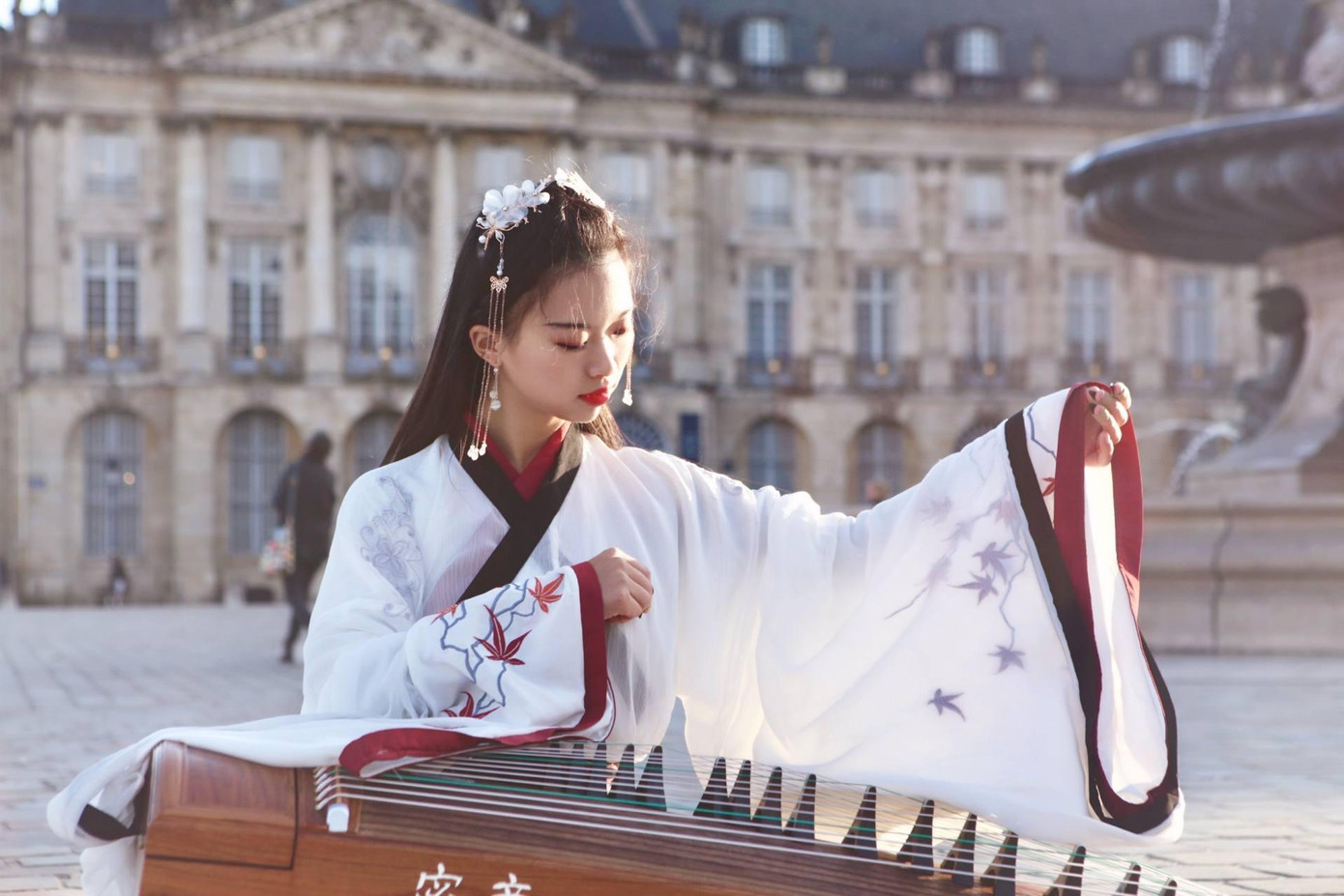 Bành Tĩnh Toàn mặc đồ cổ trang, gảy đàn trên đường phố Pháp. Ảnh: China Daily. Bành Tĩnh Toàn mặc đồ cổ trang, gảy đàn trên đường phố Pháp. Ảnh: China Daily.