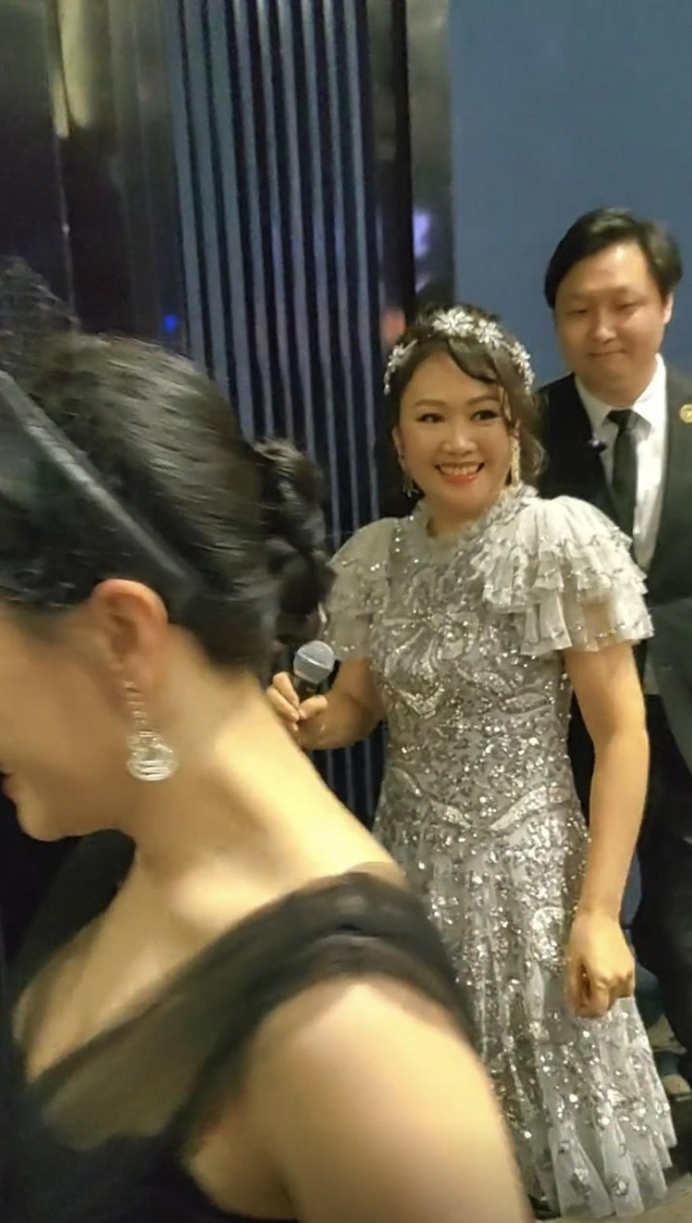 Lương Tiểu Băng mặc đầm lấp lánh và được vệ sĩ hộ tống. Ảnh: HK01. Lương Tiểu Băng mặc đầm lấp lánh và được vệ sĩ hộ tống. Ảnh: HK01.