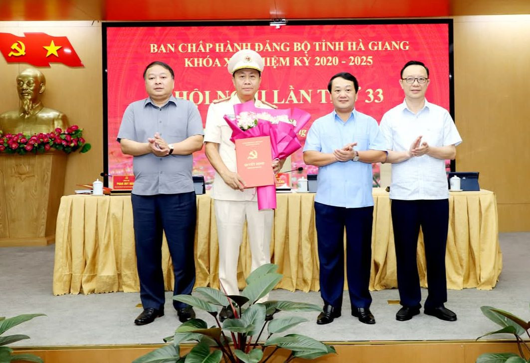 Các đồng chí lãnh đạo trao quyết định của Ban Bí thư và tặng hoa chúc mừng Đại tá Nguyễn Đức Thuận.