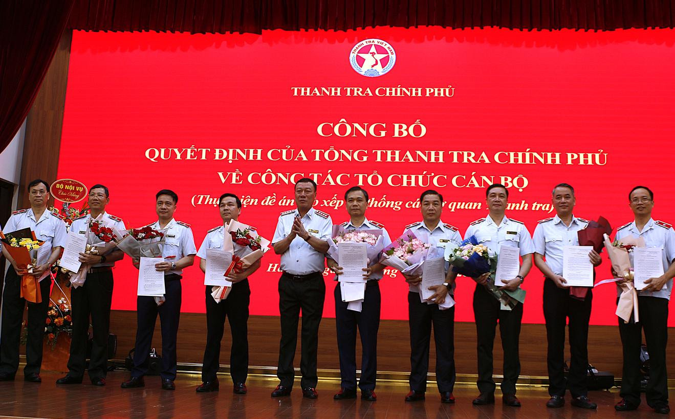 Tổng Thanh tra Chính phủ Đoàn Hồng Phong trao quyết định và tặng hoa chúc mừng các cán bộ được điều động, tiếp nhận và bổ nhiệm. Ảnh: TTCP