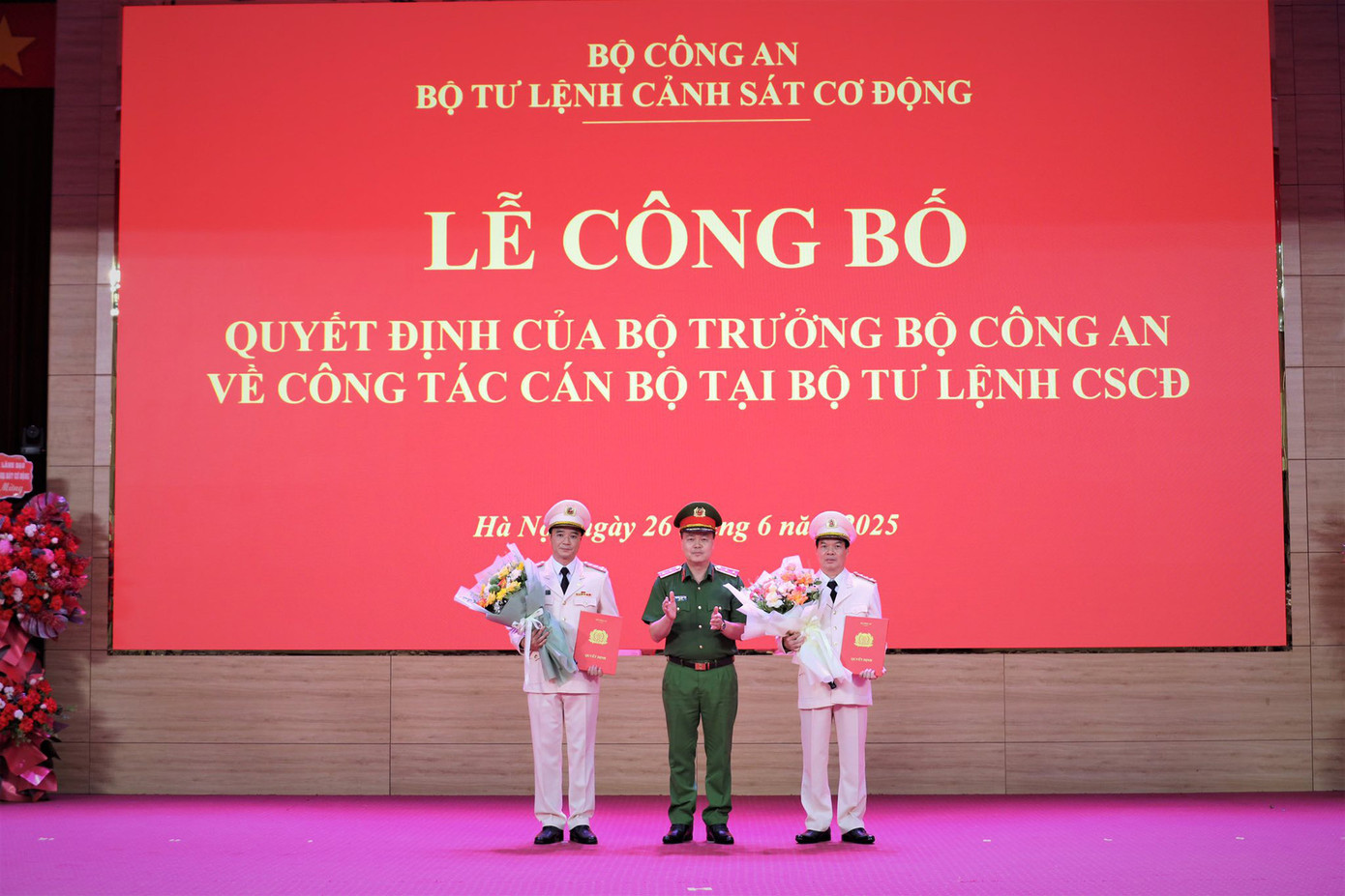 Trung tướng Nguyễn Ngọc Vân - Tư lệnh Cảnh sát cơ động (ở giữa) trao quyết định, tặng hoa chúc mừng Đại tá Vũ Cao Sơn (bên trái) và Đại tá Đỗ Tiến Thùy. Ảnh: Bộ Tư lệnh Cảnh sát cơ động