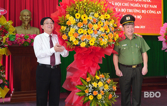 Ông Hồ Quốc Dũng, Bí thư Tỉnh ủy Bình Định tặng hoa chúc mừng thiếu tướng Lê Quang Nhân. Ảnh: Báo Bình Định