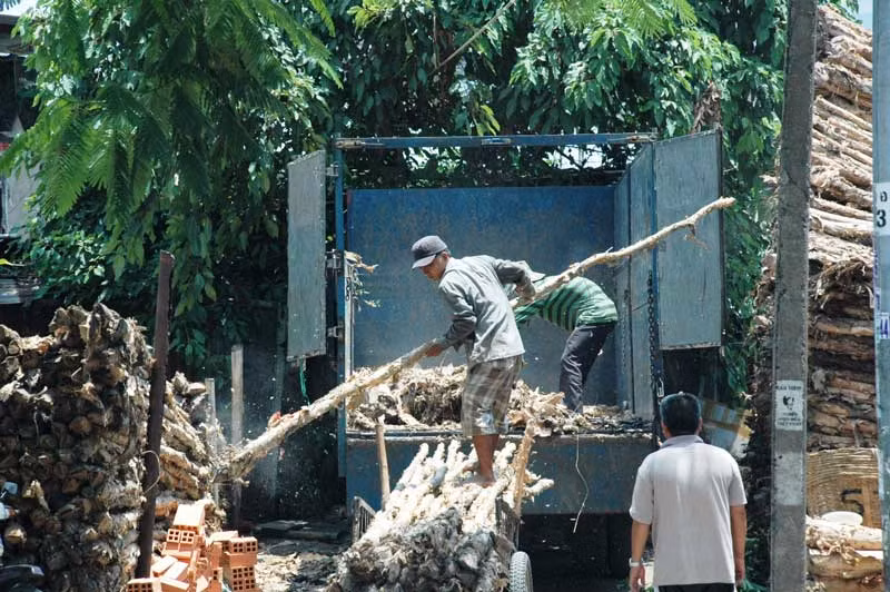 Giữa trưa, những công nhân bốc xếp vẫn tiếp tục công việc tháo dỡ các cây gỗ
