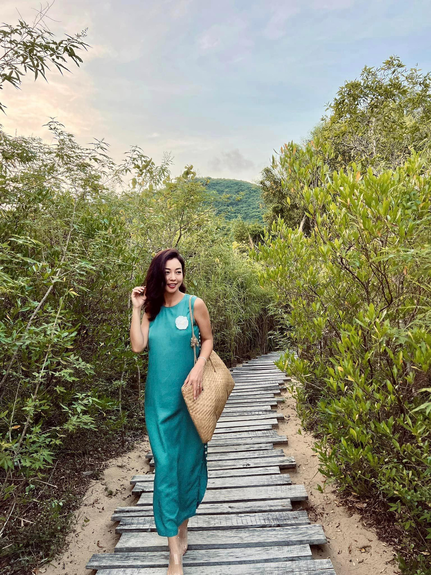 Hoa hậu Jennifer Phạm khoe dáng xinh đẹp, yêu kiều với bộ váy lụa màu xanh.