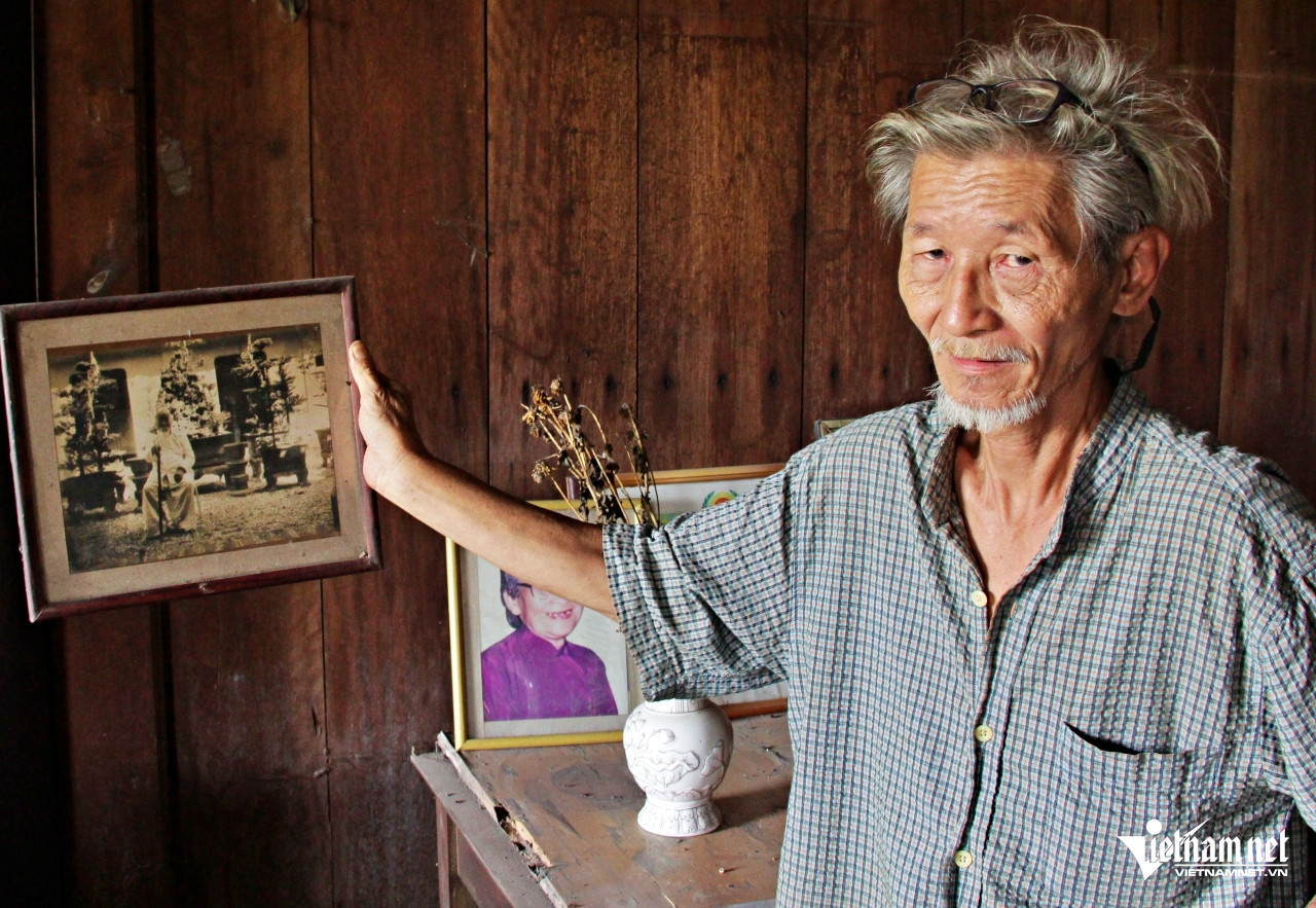 Ông Luận giới thiệu bức ảnh cụ Nguyễn Văn Giác ngồi chụp ảnh tại khoảng sân giữa nhà trước và nhà sau. Ảnh: Hà Nguyễn