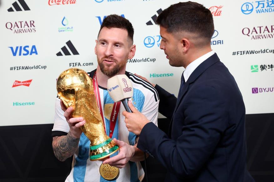 Messi cầm cúp vàng World Cup 2022 khi trả lời phóng viên