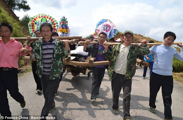 Những người đàn ông trong làng cùng khiêng chú trâu này tới một vùng núi để chôn. Những người đàn ông trong làng cùng khiêng chú trâu này tới một vùng núi để chôn