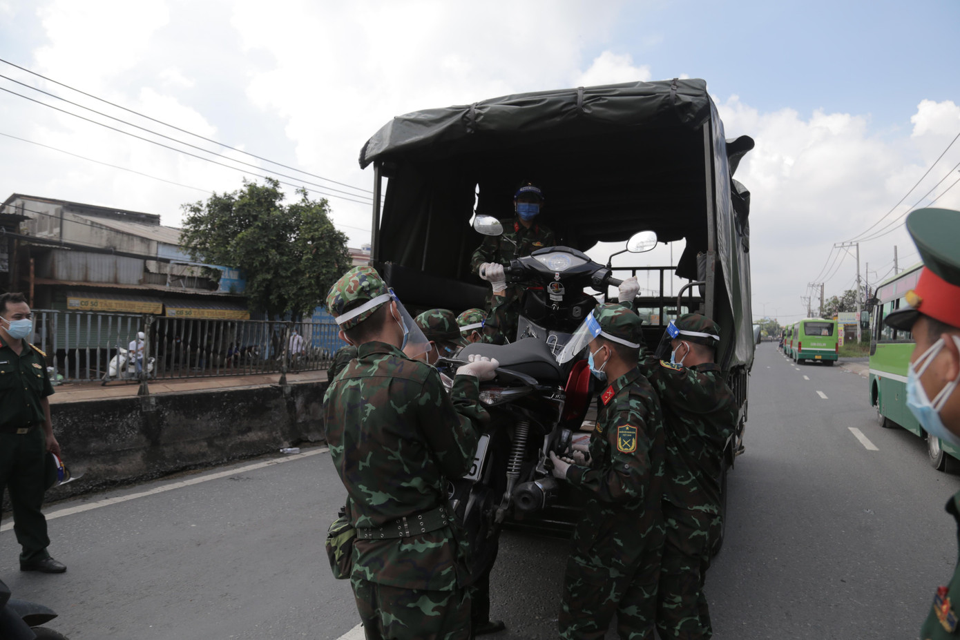 Quân đội đưa xe máy của người dân lên ô tô tải để chở về địa phương