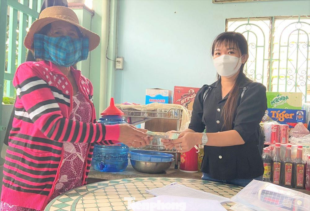 Bà Táo (bìa trái) mang tiền trợ cấp đến khu phố để trả lại