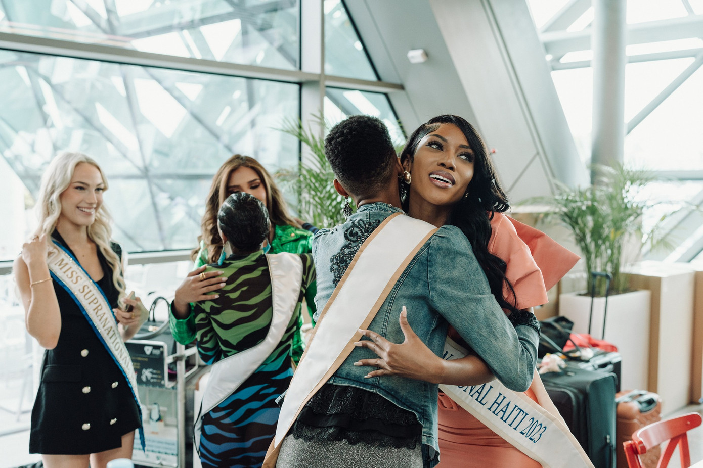 Các người đẹp đến từ khắp nơi trên thế giới vui mừng chào hỏi nhau ở sân bay.