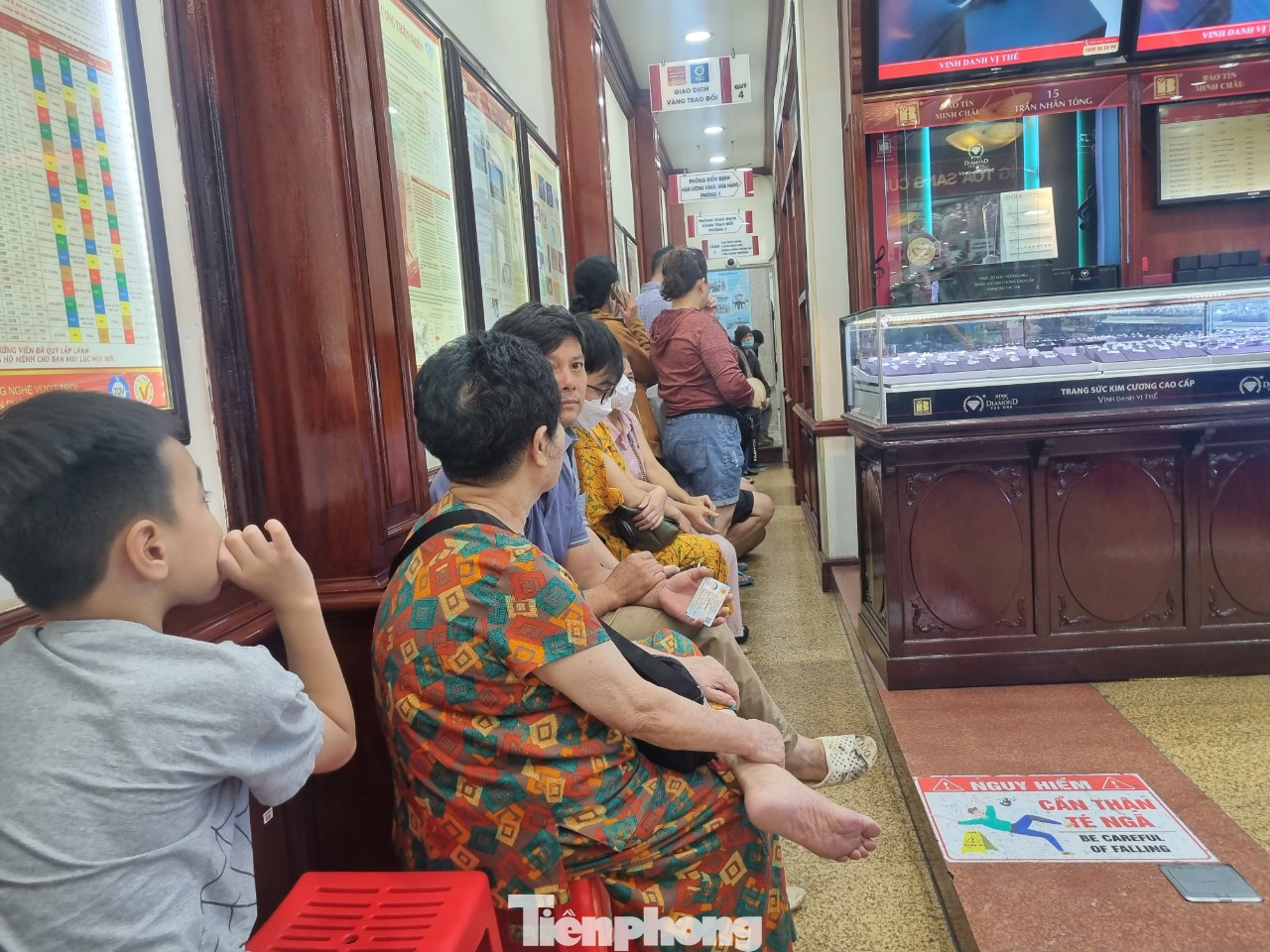 Khách hàng ngồi xếp hàng trước giờ giao dịch trong cửa hàng.