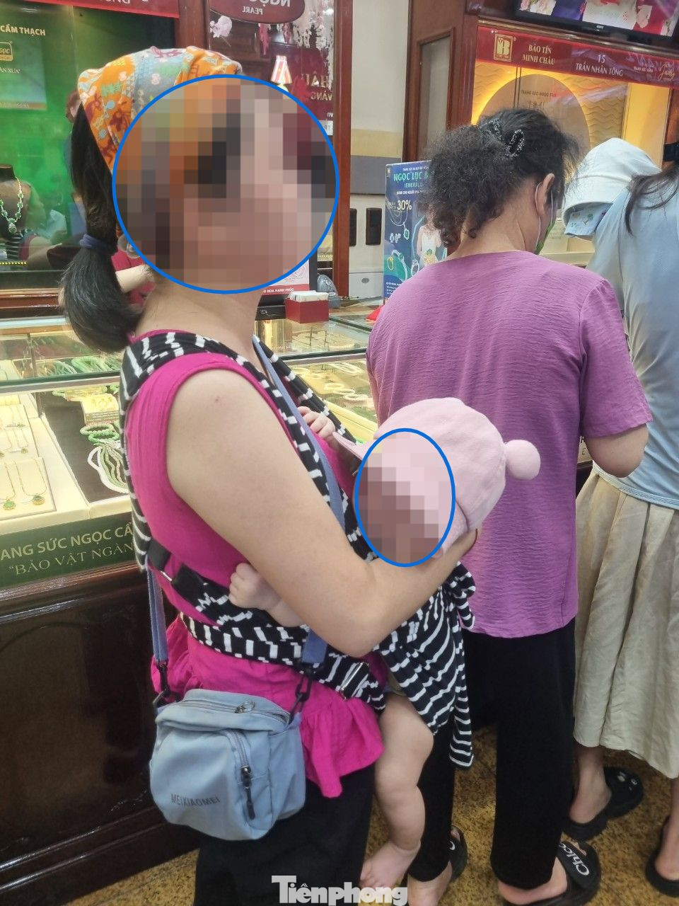 Bà mẹ bế theo em bé 3 tháng tuổi xếp hàng chờ mua vàng.