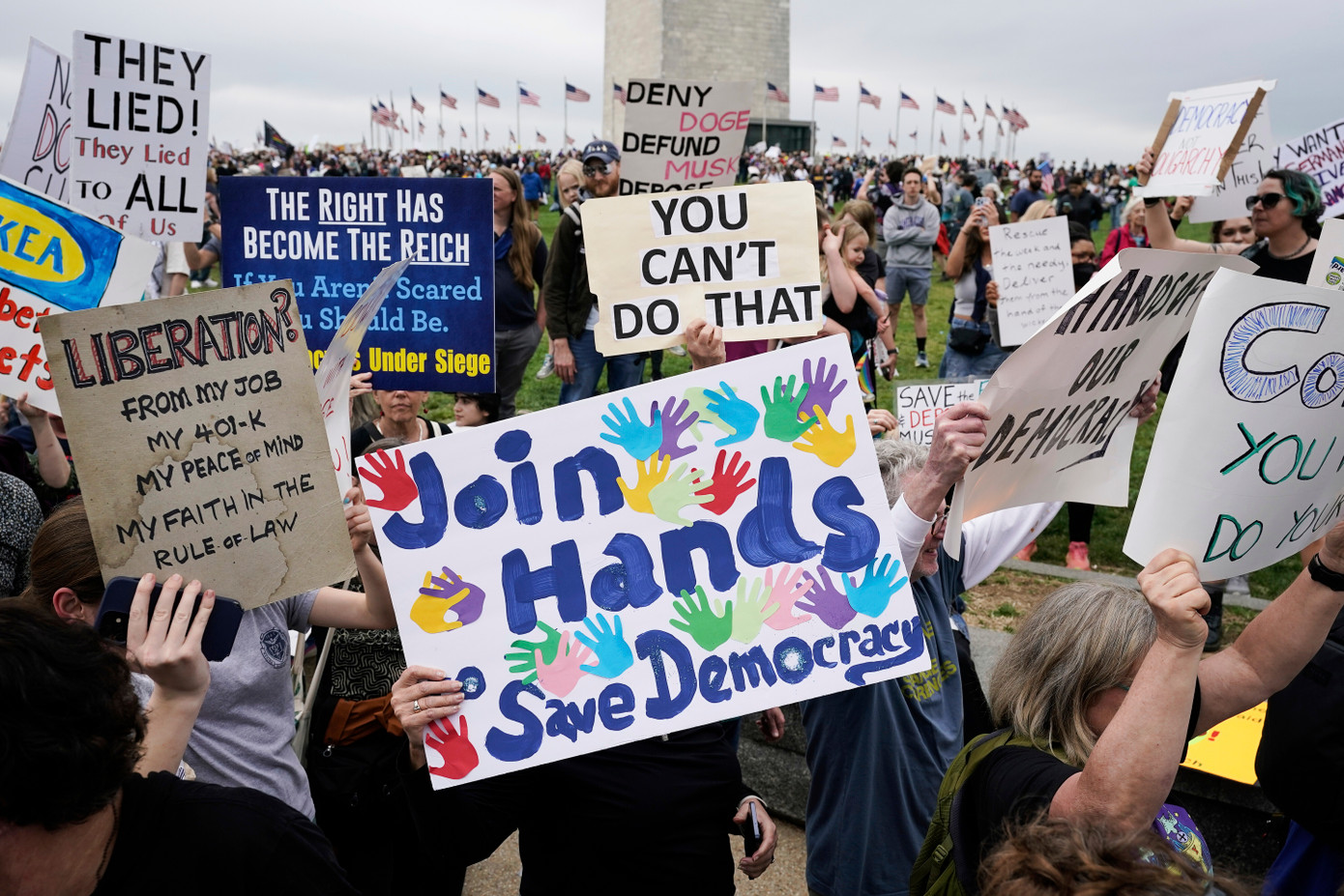 Đám đông giơ các biểu ngữ trong cuộc biểu tình phản đối Tổng thống Mỹ Donald Trump tại Đài tưởng niệm Washington, ngày 5/4. (Ảnh: AP)