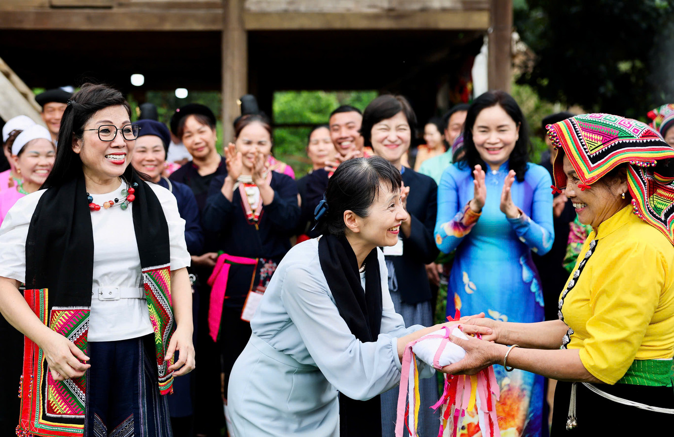 Đại diện đồng bào Thái tặng Phu nhân Lê Thị Bích Trân và Phu nhân Ishiba Yoshio khăn Piêu và quả còn. Ảnh: Nhật Minh