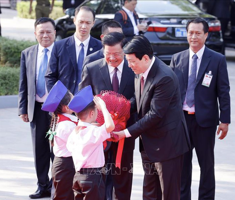 Thiếu nhi Thủ đô Vientiane tặng hoa, chào mừng Chủ tịch nước Lương Cường tại lễ đón. Ảnh: TTXVN.