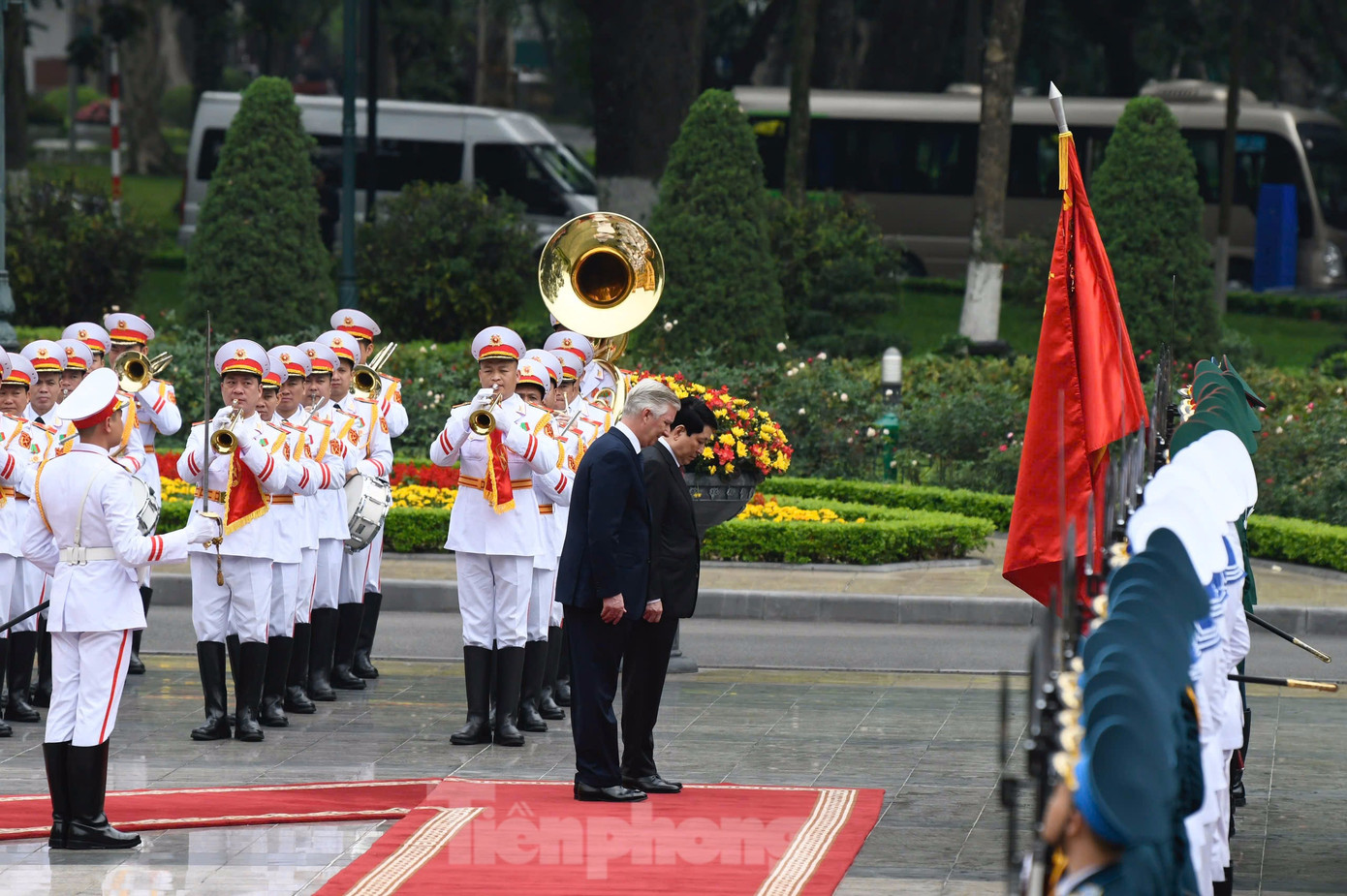Chủ tịch nước Lương Cường và Nhà vua Bỉ cúi chào trước quân kỳ. (Ảnh: Như Ý)