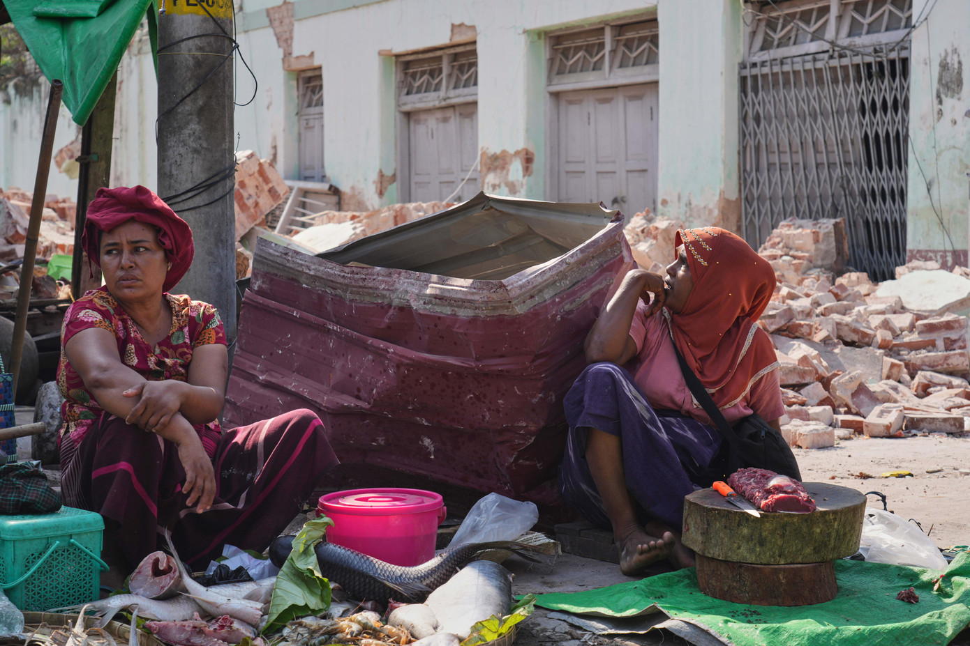 Hai người bán cá ở khu chợ cạnh những tòa nhà bị hư hại sau trận động đất ở Naypyitaw, ngày 1/4. (Ảnh: AP) Hai người bán cá ở khu chợ cạnh những tòa nhà bị hư hại sau trận động đất ở Naypyitaw, ngày 1/4. (Ảnh: AP)