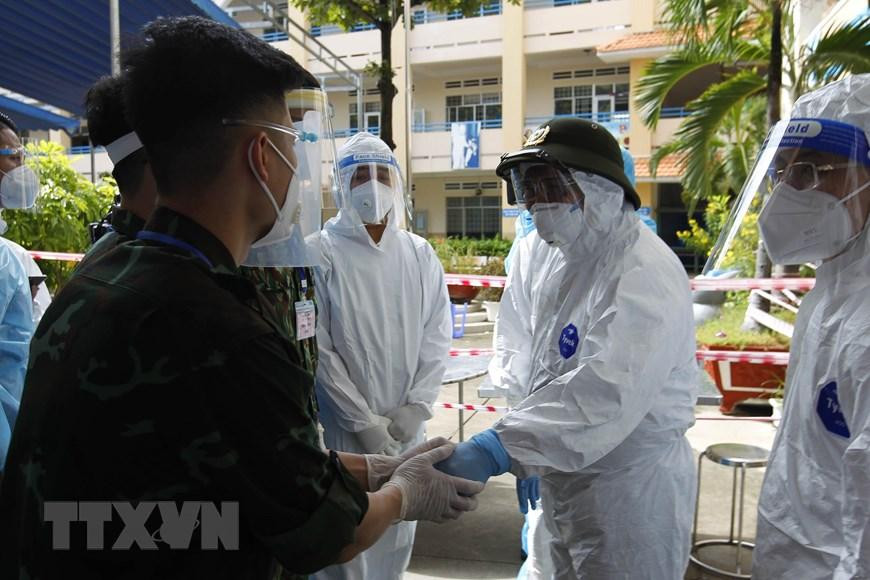 Thủ tướng Phạm Minh Chính thăm hỏi, động viên các cán bộ, chiến sỹ, y bác sỹ đang khám điều trị tại khu cách ly tập trung tạm thời ở Trường THCS Thạnh Mỹ Lợi, phường Cát Lái, thành phố Thủ Đức. (Ảnh: Thanh Vũ/TTXVN).