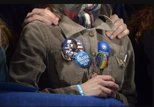 Những người ủng hộ ông Obama nắm tay nhau khi ngồi nghe ông Obama diễn thuyết 