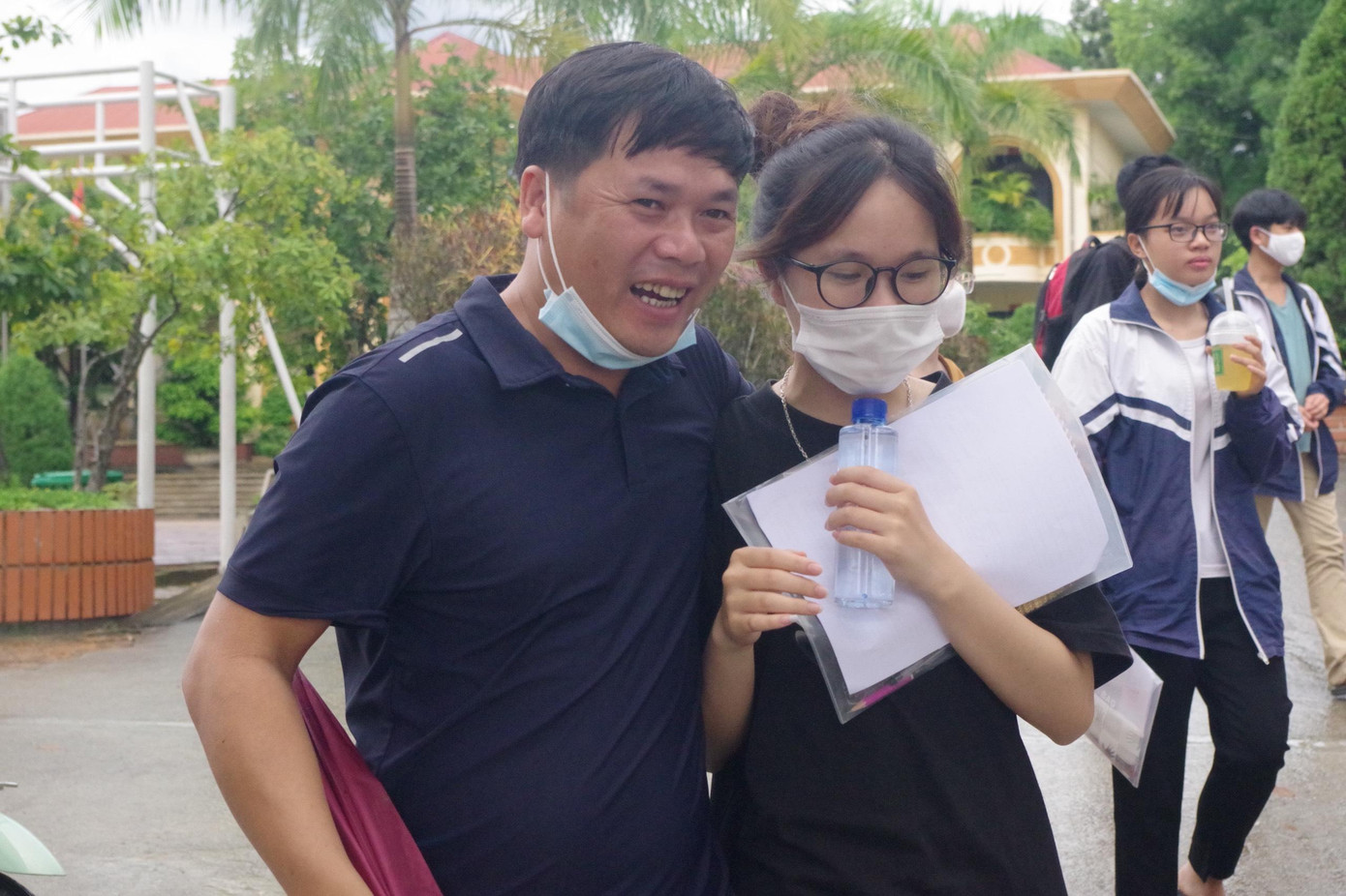 Phụ huynh vui mừng đón đợi con em mình ngoài điểm thi, chúc mừng các sĩ tử đã hoàn thành kỳ thi căng thẳng.