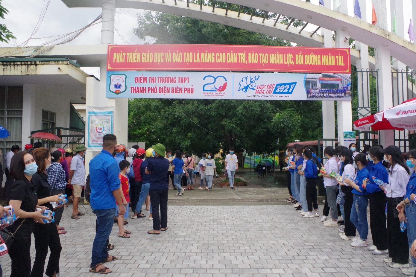 Đội "hậu phương" ngoài cổng trường đứng đợi sẵn để đón chào, cổ vũ các sĩ tử.