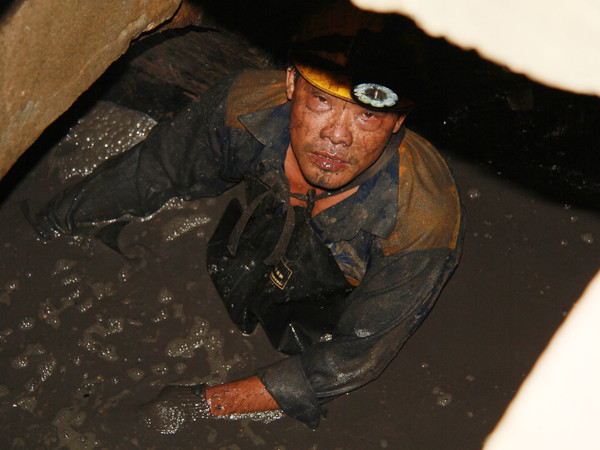 Bùn dưới cống ngập ngang ngực công nhân thoát nước Ảnh: Trường Phong