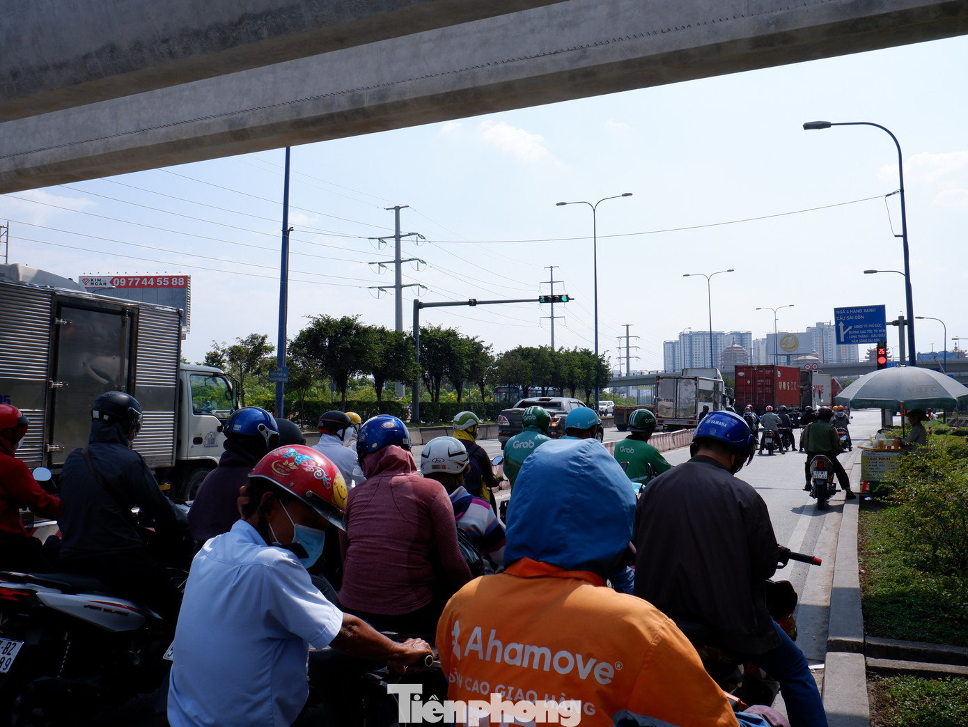 Người dân dưới bóng râm trên đường Võ Nguyên Giáp, TP Thủ Đức, để tránh nắng nóng khi chờ đèn đỏ vào trưa 27/1.