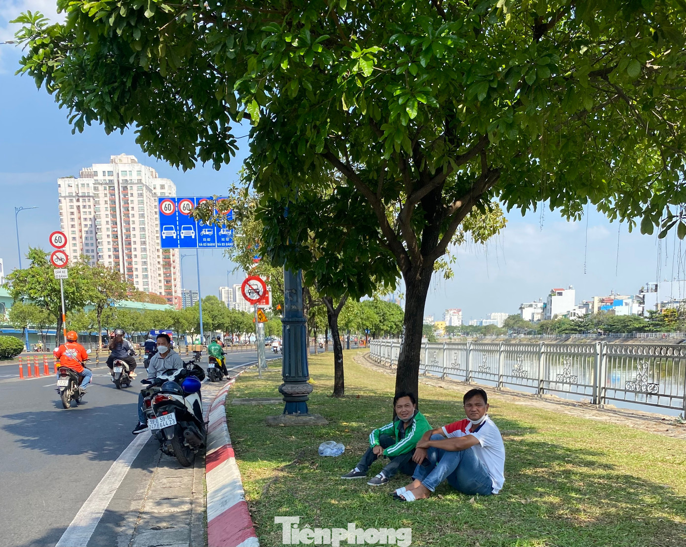 Khu vực bóng mát dưới tán cây xanh ven đường trở thành nơi tránh nắng lý tưởng của người tham gia giao thông trong buổi trưa nắng gắt.