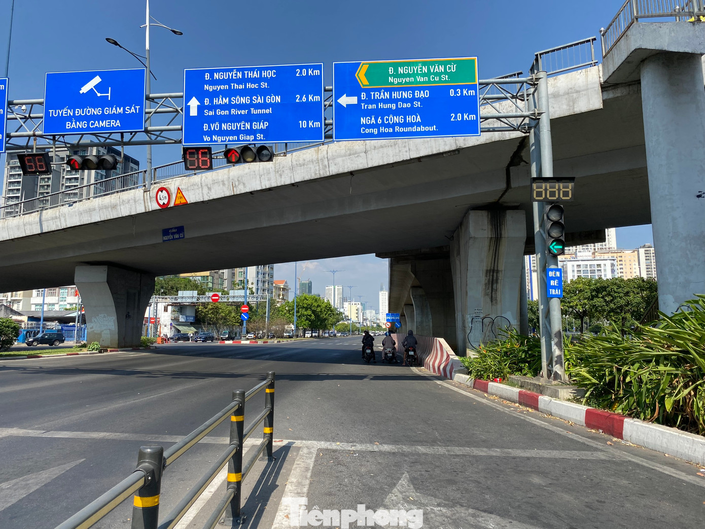 Người dân tận dụng bóng mát từ cây xanh, công trình để tránh nắng khi phải dừng chờ đèn tín hiệu giao thông trên đường Võ Văn Kiệt (quận 5).