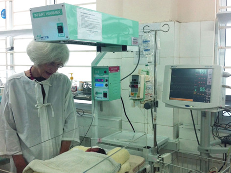 Bà Suzanna Lubran bên cạnh em bé sinh non nằm trên giường sưởi bà vận động tài trợ ngày 8/11. Bà Suzanna Lubran bên cạnh em bé sinh non nằm trên giường sưởi bà vận động tài trợ ngày 8/11