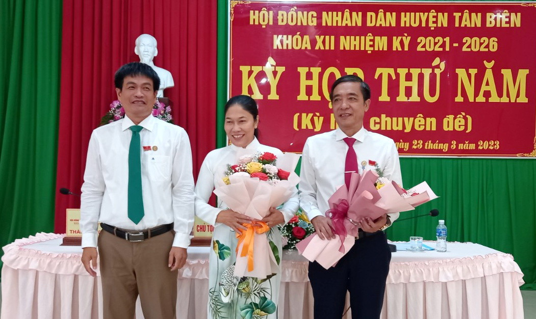 Ông Thành Từ Dũ - Bí thư Huyện ủy, Chủ tịch HĐND huyện Tân Biên (bìa trái) tặng hoa chúc mừng tân Chủ tịch UBND huyện Nguyễn Thị Thành. Ảnh: B.T.N