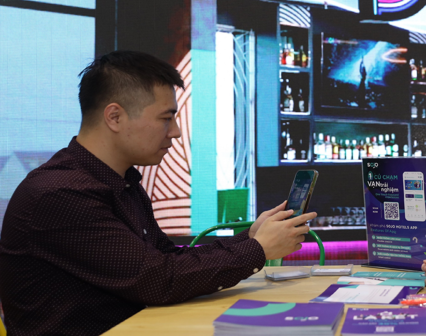 Khách hàng quét mã QR để trải nghiệm SOJO thay vì xem tài liệu bản in để bảo vệ môi trường