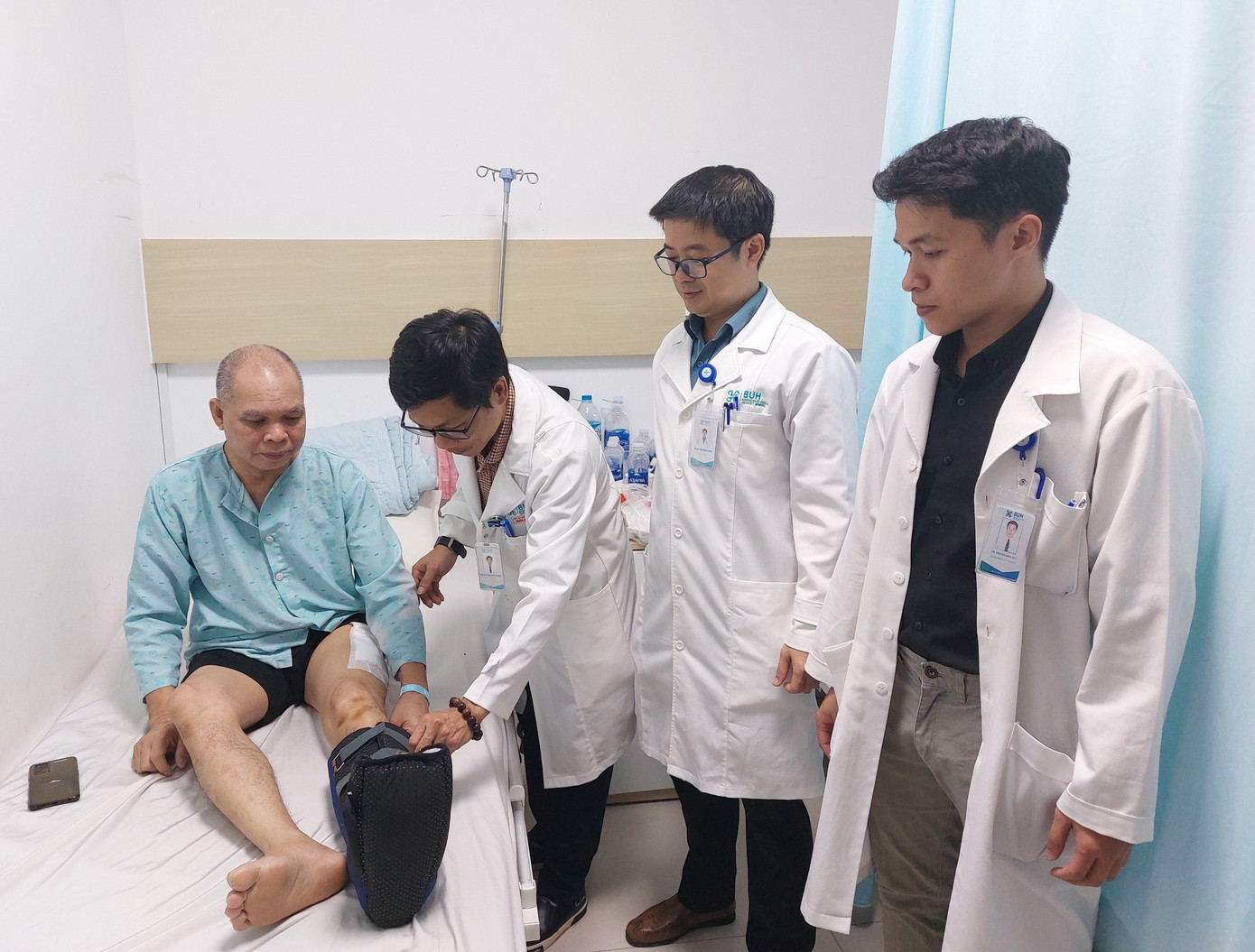 BS.CKII. Trần Mậu Phong - phẫu thuật viên chính và các bác sĩ khoa chấn ngoại thương chỉnh hình thăm khám cho bệnh nhân BS.CKII. Trần Mậu Phong - phẫu thuật viên chính và các bác sĩ khoa chấn ngoại thương chỉnh hình thăm khám cho bệnh nhân