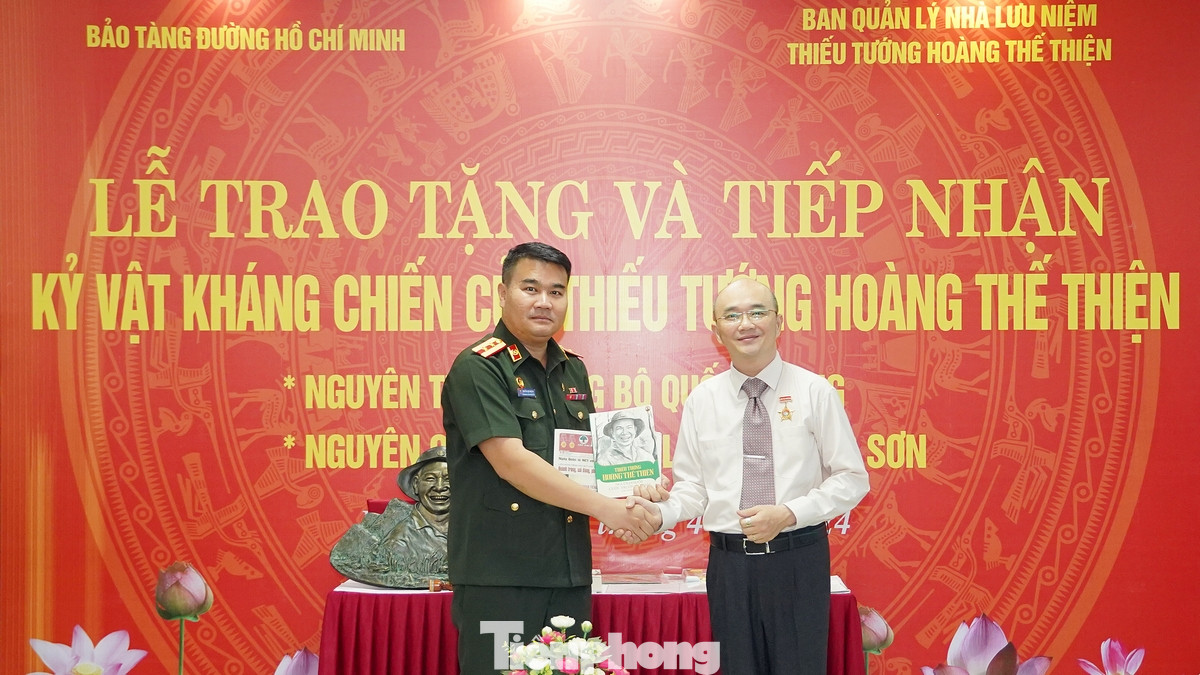 Đại diện gia đình Thiếu tướng Hoàng Thế Thiện tặng sách cho Trung tá Sulaxay Sucsengta, Phó trưởng phòng Tùy viên quốc phòng CHDCND Lào tại Việt Nam.