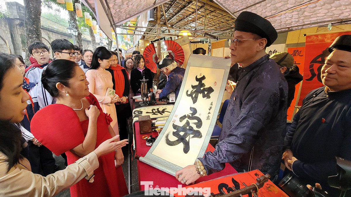 Phu nhân Tổng thống Philippines được thầy đồ tặng chữ trong buổi đi thăm phố cổ và chợ hoa Tết Hà Nội.