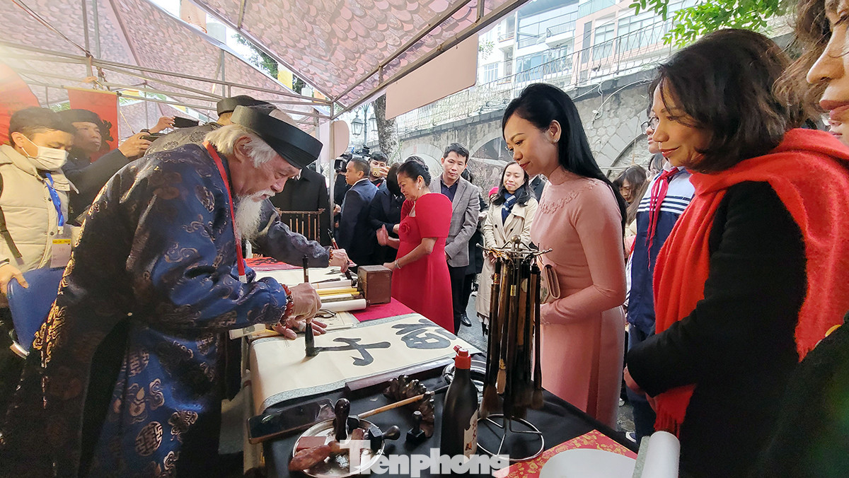 Hai phu nhân tham quan không gian thư pháp.