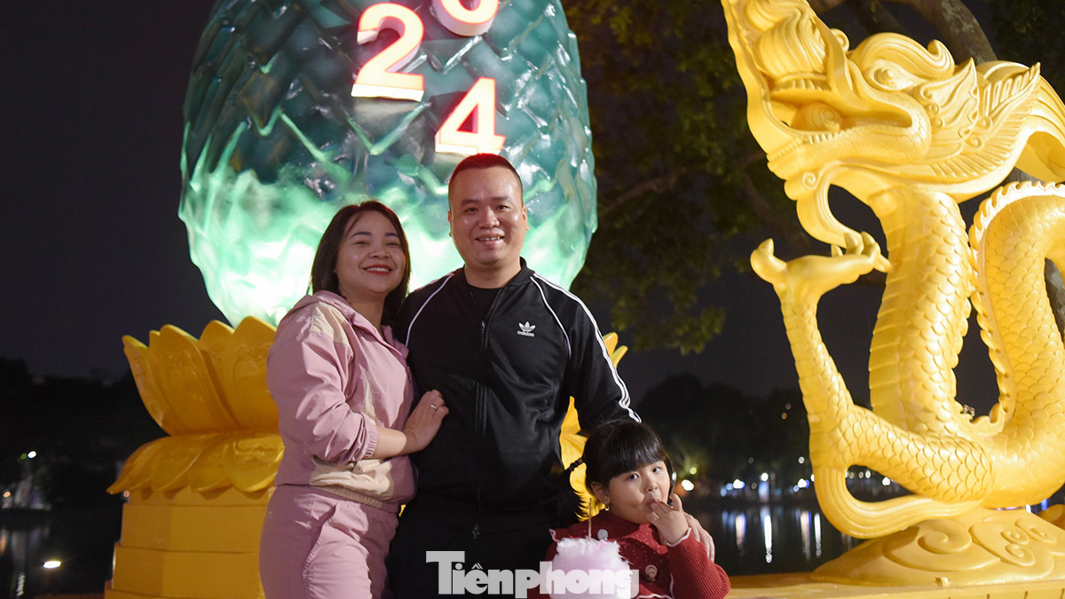 Một gia đình tranh thủ chụp hình bên hồ Hoàn Kiếm.