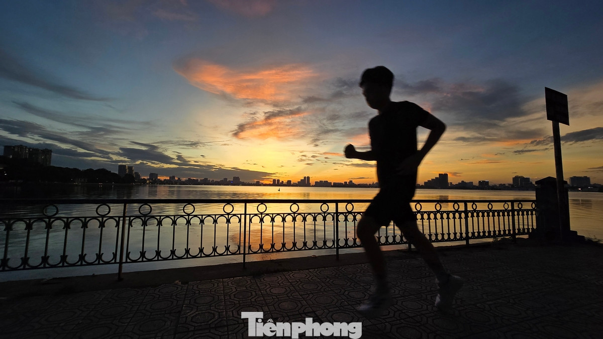 Một người chạy tập thể dục dưới ánh vàng tuyệt đẹp của buổi hoàng hôn Hồ Tây.