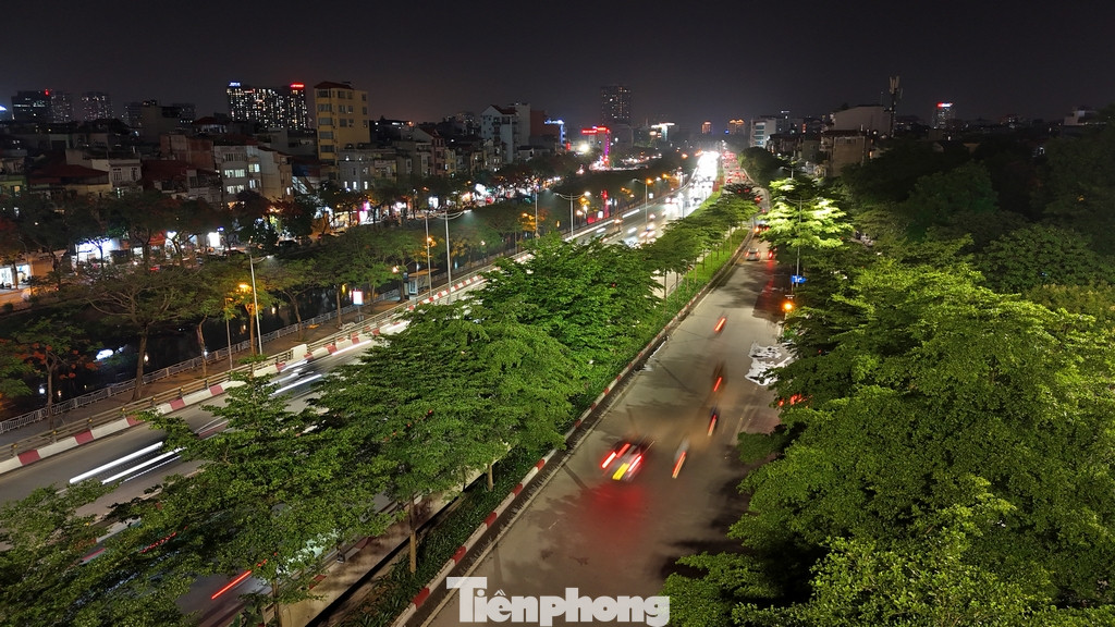 Hình ảnh tại khu vực đường vành đai tại khu vực Cầu Giấy về đêm với màu xanh phủ kín của cây xanh đô thị.