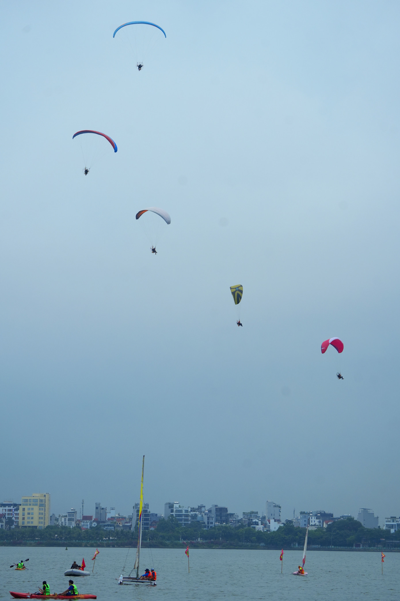 Bắt đầu sự kiện, 5 chiếc dù lượn gắn động cơ đã cất cánh trên bầu trời khu vực trung tâm quận Tây Hồ.