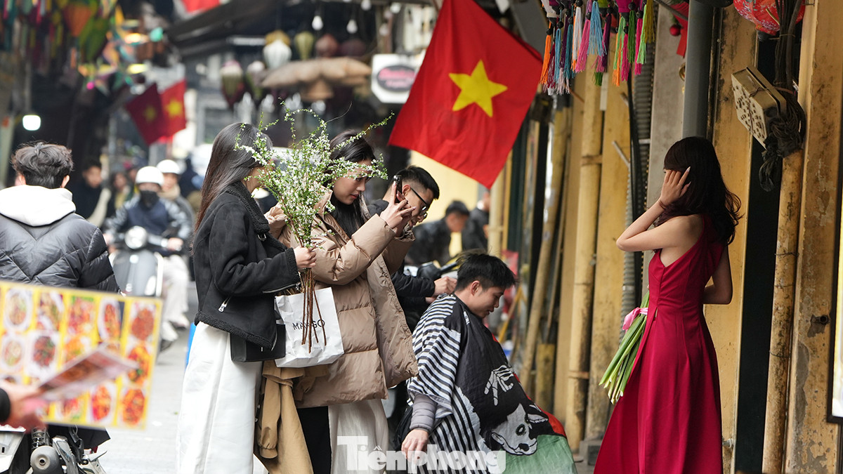 Phố Tạ Hiện vẫn nhộn nhịp dù đã là chiều 30 Tết, nhiều bạn trẻ trong trang phục áo dài truyền thống đủ màu sắc tạo dáng chụp ảnh.