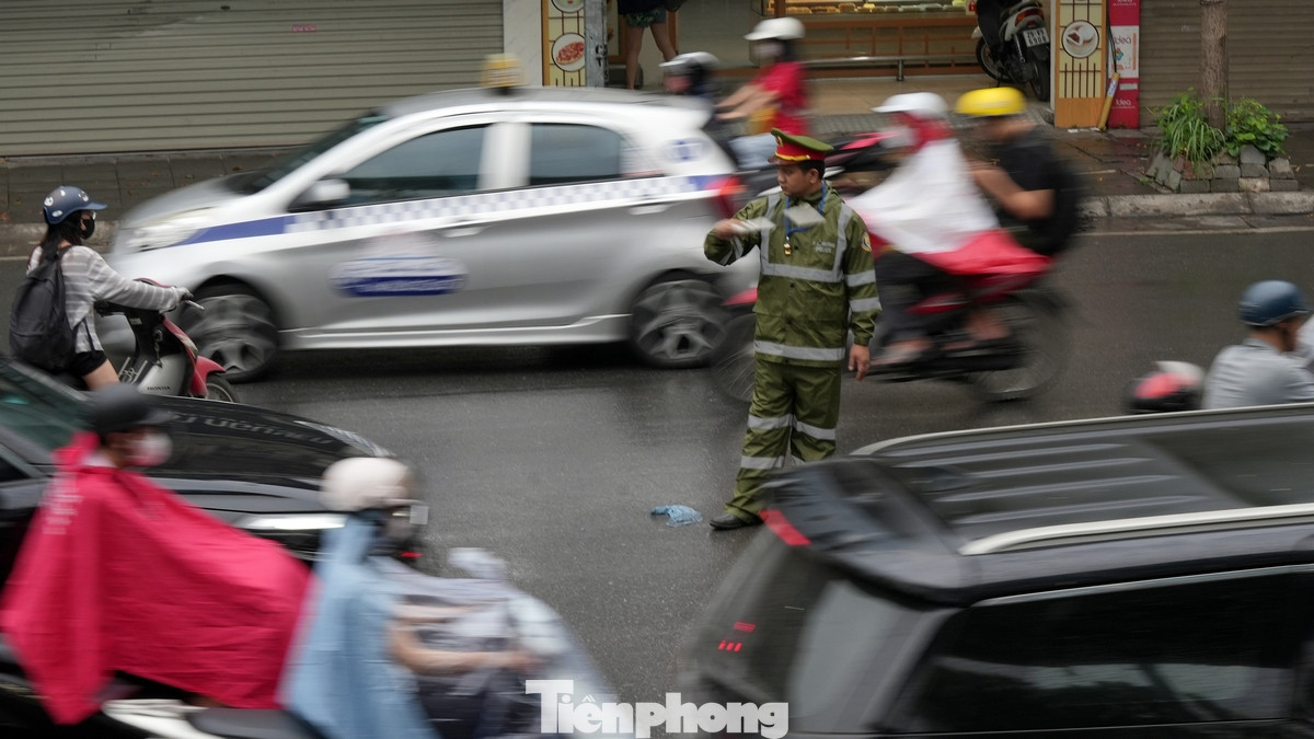 Lực lượng công an, cảnh sát giao thông ứng trực ở nhiều "điểm đen" ùn ứ để điều tiết giao thông dưới cơn mưa dông đầu giờ sáng.