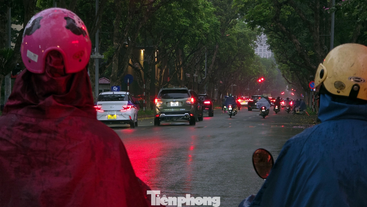 Cơn dông kèm mưa nhỏ khiến đường phố Hà Nội tối đen, giao thông đúng thời điểm đi làm của người dân bị ảnh hưởng.