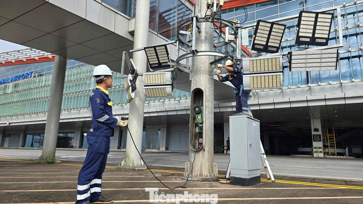 Đội ngũ kỹ thuật của sân bay Vân Đồn đang cho hạ toàn bộ hệ thống đèn chiếu sáng trên cao ngoài sân đỗ đồng thời cố định lại bằng dây thép.