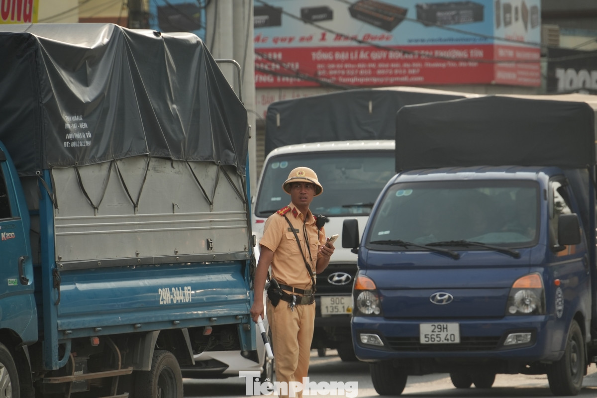 Lực lượng công an vất vả phân luồng các phương tiện đi lên cầu vượt đoạn qua thị trấn Thường Tín.
